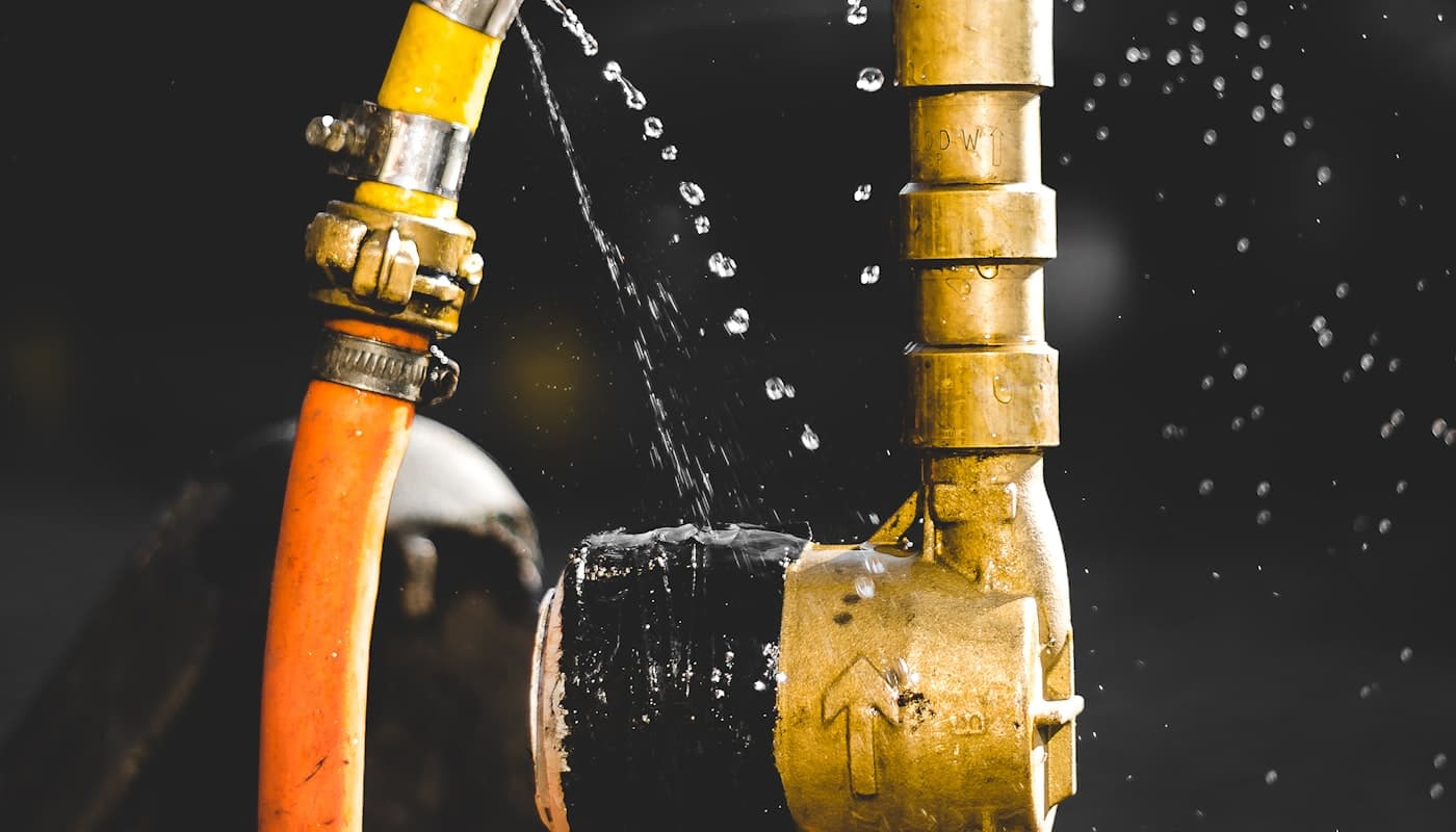 Water spraying from a leaking brass pipe fitting