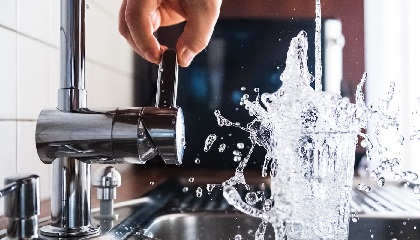 Water splashing in a kitchen sink from a running tap