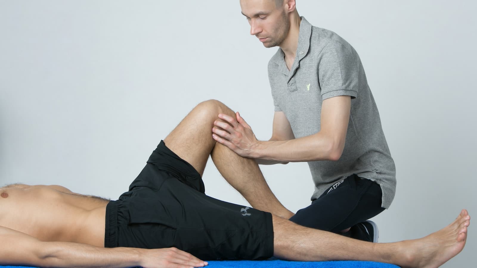 A physiotherapist treating a patient's knee on a treatment table